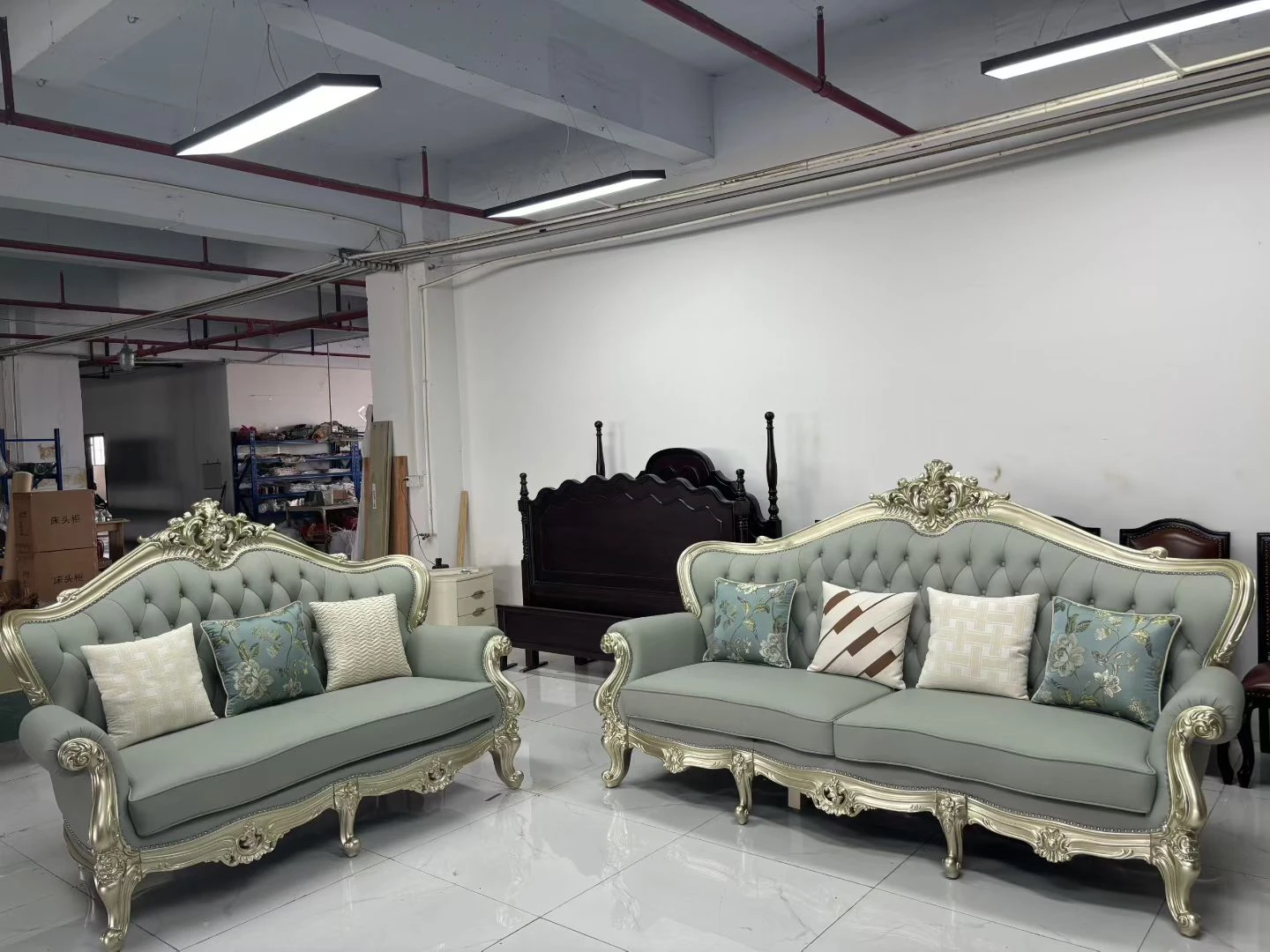 Two grey tufted sofas with gold accents